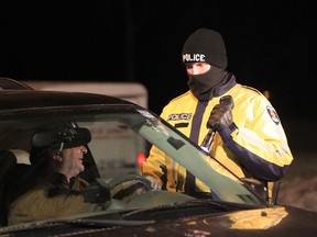 A Windsor Police officer questions a motorist during a joint forces R.I.D.E. program on Riverside Drive in east Windsor in Dec. 2012. (JASON KRYK/The Windsor Star)