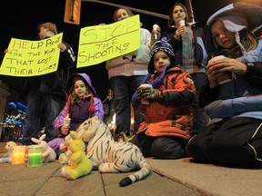 From left, foreground: Kimmie, Dale and Kayla Beattie -- children of Windsor resident Scott Beattie -- take part in a candlelight tribute to victims of the shooting massacre in Newtown, CT. Photographed in downtown Windsor on Dec. 14, 2012. (Jason Kryk / The Windsor Star)