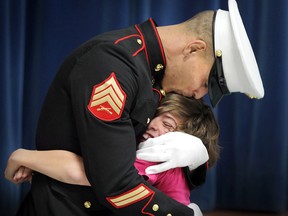 Mike Desjardins, a Sgt. In U. S. Marine Corp reserves hugs his son Justin Desjardins, age 11, as the two reunite at St. John the Baptist Catholic Elementary School  in Belle River, Ontario on February 9, 2012.  Mike Desjardins surprised his son after returning from Afghanistan following a tour of duty.    (JASON KRYK/ The Windsor Star)