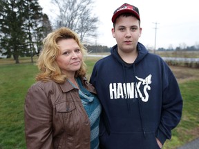 Liz Salter walks with her son Matt, 14, near their Harrow, Ont. home after he was dropped off by his school bus. Salter is concerned about his safety. Matt suffered a brain injury after being hit by a car in 2010. (DAN JANISSE/The Windsor Star)