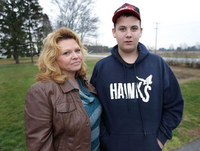 Liz Salter walks with her son Matt, 14, near their Harrow, Ont. home after he was dropped off by his school bus. Salter is concerned about his safety. Matt suffered a brain injury after being hit by a car in 2010. (DAN JANISSE/The Windsor Star)