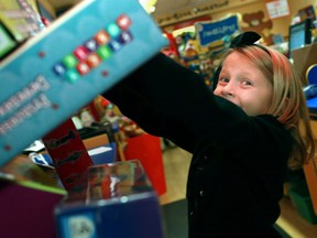 Victoria Barrette-Watorek, 7, puts toys into the Salvation Army donation box at the Build-A-Bear Workshop in the Devonshire Mall on Dec. 3, 2012. (Dax Melmer / The Windsor Star)