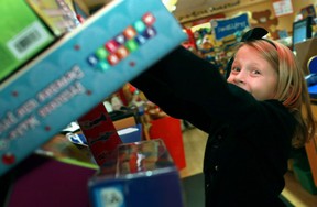 Victoria Barrette-Watorek, 7, puts toys into the Salvation Army donation box at the Build-A-Bear Workshop in the Devonshire Mall on Dec. 3, 2012. (Dax Melmer / The Windsor Star)