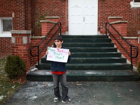 Connor Rodrigues, 10, holds a sign offering free turkey boxes outside the Mt. Zion Full Gospel Church in downtown Windsor, Saturday, Dec. 22, 2012.  The church was giving out free boxes of turkey dinners for Christmas. (DAX MELMER/The Windsor Star)