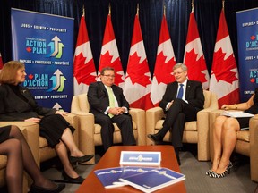 Prime Minister Stephen Harper, right, sits with Finance Minister Jim Flaherty, left, and female business leaders in Toronto on Saturday, Jan. 12, 2013 before a roundtable discussion on Canada's economy. (THE CANADIAN PRESS/Michelle Siu)