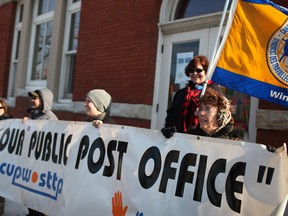 Protesters  gathered outside the Sandwich post office to protest the closing of the branch hold a banner that reads 'Hands off our public post office,' Saturday, January 26, 2013.  (DAX MELMER/The Windsor Star)