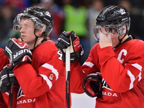 Canadian captain Ryan Nugent-Hopkins, right, holds his face next to teammate Morgan Rielly, left, after losing to Russia during overtime bronze medal hockey action at the IIHF World Junior Championships in Ufa, Russia, on Saturday, Jan. 5, 2013. THE CANADIAN PRESS/Nathan Denette