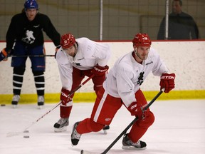 Wings defenceman Ian White, right, skates during drills at the Troy Sports Center in Troy. In the background are Oilers defenceman Jeff Petry, from left, and Wings forward Patrick Eaves.  (AP photo/Carlos Osorio)