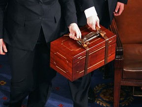 Senate pages carry bound wooden boxes containing the Electorial College votes from the 50 states into the House of Representatives chamber at the U.S. Captiol January 4, 2013 in Washington, DC.