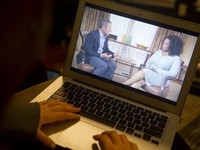 Photo illustration showing a woman watches on her computer as Oprah Winfrey interviews cyclist Lance Armstrong about doping while competing professionally in the sport, as seen from Washington, DC, on January 17, 2013. The interview will run in two parts on Winfrey's OWN cable network and website. AFP PHOTO / Saul LOEBSAUL LOEB/AFP/Getty Images