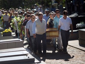 Relatives and friends carry the coffins of two brothers, Pedro and Marcelo Salla, who died in a nightclub fire, as they prepare to bury them at a cemetery in Santa Maria, Brazil, Monday, Jan. 28, 2013. A fast-moving fire roared through the crowded, windowless Kiss nightclub in this southern Brazilian city early Sunday, killing more than 230 people. Many of the victims were under 20 years old, including some minors. (AP Photo/Felipe Dana)