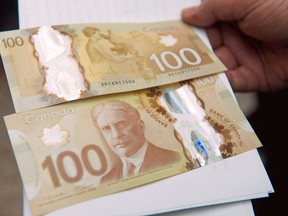 The Bank of Canada's new circulating $100 bill, Canada's first polymer bank note, is shown in Toronto on Monday Nov. 14, 2011. Disclosing details of behind-the-scenes discussions about tales of melting banknotes could endanger national security or international relations, says Canada's central bank. THE CANADIAN PRESS/Nathan Denette