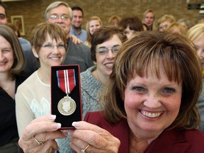 Carol Derbyshire, front, Exec. Director The Hospice of Windsor and Essex County shares her Queen's Diamond Jubilee Award witt co-workers, friends and volunteers on Empress Street, Friday January 18, 2013. Derbyshire received the award from Hon. Dwight Duncan during a short ceremony Friday. (NICK BRANCACCIO/The Windsor Star)