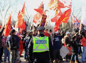 A Windsor Police officer monitors Idle No More protestors blocking the entrance to the Ambassador Bridge in Windsor, Ontario on January 16, 2016. (JASON KRYK/The Windsor Star)