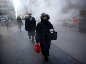A woman bundles against the cold as she walks through steam from the street January 23, 2013 in New York. Two-thirds of the US was in the grips of a blast of cold Arctic air Wednesday with temperatures falling to some of the lowest marks in years and wind chills plummeting to dangerously low levels. AFP PHOTO/DON EMMERTDON EMMERT/AFP/Getty Images