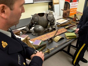 The RCMP display some of the hundreds of historical artifacts discovered at a suburban home, at a news conference in Halifax on Friday, Jan. 25, 2013. John Mark Tillmann has been charged with possessing stolen property. THE CANADIAN PRESS/Andrew Vaughan