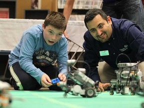 In this file photo, William Bechard, 11, and Ziad Kobti, Director of  the School of Computer Science at the University of Windsor, operate miniature robots during the first annual WE-Tech Alliance robotics open house held at the Windsor Public Library on October 11, 2012. (JASON KRYK/ The Windsor Star)
