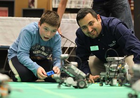 In this file photo, William Bechard, 11, and Ziad Kobti, Director of  the School of Computer Science at the University of Windsor, operate miniature robots during the first annual WE-Tech Alliance robotics open house held at the Windsor Public Library on October 11, 2012. (JASON KRYK/ The Windsor Star)