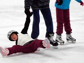 Madalyn Gillis, 7, takes a tumble while skating with Evan Arvic, 14, and sister Sarah Gillis, 9, during New Year's Eve family party at Lanspeary Park December 31, 2012.  (NICK BRANCACCIO/The Windsor Star)