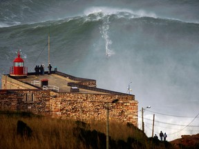 In this photo released Tuesday Jan. 29, 2013, by Nazare Qualifica organization, US surfer Garrett McNamara rides a wave off Praia do Norte beach in Nazare, Portugal, on Monday Jan. 28, 2013. McNamara is said to have broken his own world record for the largest wave surfed when he caught this wave reported to be around 100ft, off the coast of Nazare on Monday.