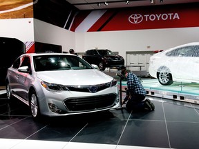 Workers prepare a display at the Toyota Motor Corp. booth ahead of the 2013 North American International Auto Show (NAIAS) in Detroit, Michigan, U.S., on Sunday, Jan. 13, 2013. The Detroit auto show runs through Jan. 27 and will display over 500 vehicles, representing the most innovative designs in the world. Photographer: David Paul Morris/Bloomberg
