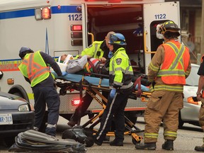 Windsor-Essex EMS paramedics and Windsor firefighters remove a male victim of a hit and run car accident at the corner of University Avenue west and Bridge Avenue in Windsor, Ontario on January 30, 2013. Firefighters used the jaws of life to remove the driver's-side door of the Honda that was struck. (Jason Kryk/The Windsor Star)