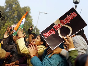 In this photograph taken on December 23, 2012 an Indian demonstrator (C) taunts the police during a protest calling for better safety for women following the rape of a student last week, in front the India Gate monument in New Delhi. A government panel reviewing India's sex crime laws after the fatal gang-rape of a student in New Delhi proposed tougher jail terms on January 23, 2013 but stopped short of calling for the death sentence. AFP PHOTO/ Andrew Caballero-Reynolds/