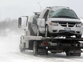 Beau's Collision tow truck operator drives away from the scene of a rollover accident where the driver of a Dodge Caravan lost control on North Talbot Road near Naylor Side Road in Kingsville, Ont. January 31, 2013. Many county roads were snow-covered and blowing snow made for 'whiteout' conditions. (NICK BRANCACCIO/The Windsor Star).