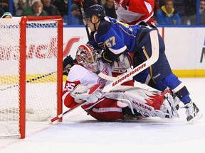 In this file photo, David Perron #57 of the St. Louis Blues falls on Jimmy Howard #35 of the Detroit Red Wings at the Scottrade Center  on December 6, 2011 in St. Louis, Missouri.  (Photo by Dilip Vishwanat/Getty Images)