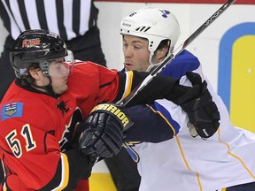 In this file photo, Calgary Flames left winger Roman Horak, left, runs into St. Louis Blues defenceman Kent Huskins while making a rush down ice during first period NHL action at the Scotiabank Saddledomeon October 28, 2011. (Photo by Colleen De Neve, Calgary Herald)