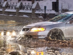 A motorist moves along a flooded street in Montreal, Monday, January 28, 2013, following a water main break.THE CANADIAN PRESS/Graham Hughes.