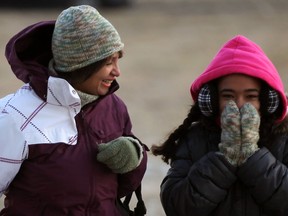 Alanna Davis and her granddaughter Hanan Davis, 10, shield themselves from a bitter cold wind on their way to buy supplies for Hanan's school project in Riverside January 22, 2013. (NICK BRANCACCIO/The Windsor Star)