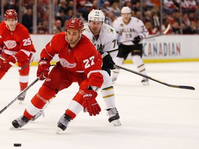 Detroit's Kyle Quincey, left, is checked by Michael Ryder of the Stars during the first period at Joe Louis Arena Tuesday. (Photo by Gregory Shamus/Getty Images)