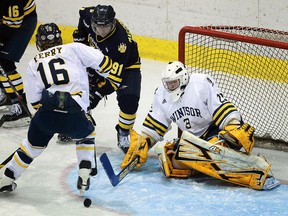 Lancers goalie Parker Van Buskirk, right, keeps a watchful eye on the puck as teammate Steve Ferry tries to check Lakehead's Mike MacDonald at Windsor Arena. (TYLER BROWNBRIDGE/The Windsor Star)