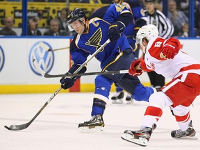 Blues captain David Backes, left, takes a shot in front of Detroit's Justin Abdelkader.  (Photo by Dilip Vishwanat/Getty Images)