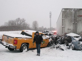 A tow truck operator attends the scene of accident on highway 401 in Newcastle, Ontario on Friday Jan. 25, 2013. At least seven people have been injured, some critically, in a multi-vehicle collision on a busy southern Ontario highway. THE CANADIAN PRESS/Doug Ives