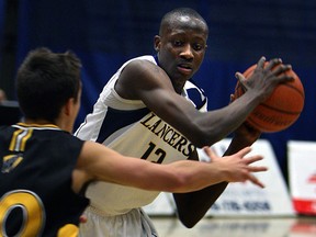 The University of Windsor's Rotimi Osuntola Jr., right, looks to pass the ball around Waterloo last year at the St. Denis Centre. (TYLER BROWNBRIDGE/The Windsor Star)