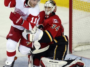 Calgary goaltender Miikka Kiprusoff, right, makes a save on Detroit's Dan Cleary in Calgary. (Grant Black/Calgary Herald)