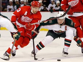 Detroit's Pavel Datsyuk  drives around Mikko Koivu of the Minnesota Wild during the second period at Joe Louis Arena on January 25, 2013 in Detroit, Michigan. (Gregory Shamus/Getty Images)