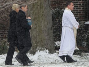 A funeral service was held Monday, Jan. 21, 2013, for Alison Easton, Alex Corchis and Katie Corchis at the All Saints Church in Windsor, Ont. A brief ceremony outside the church followed. Here, Jon Corchis, carries an urn to the ceremony.  (DAN JANISSE/The Windsor Star)