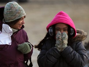 Alanna Davis and her granddaughter Hanan Davis, 10, shield themselves from a bitter cold wind on their way to buy supplies for Hanan's school project in Riverside January 22, 2013. (NICK BRANCACCIO/The Windsor Star)