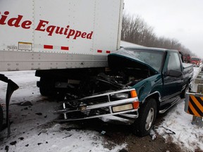 A truck is pinned under a trailer on Southbound 23 in Grand Blanc, Mich., which closed for almost three hours after a 33-vehicle wreck Thursday, Jan. 31, 2013. (AP Photo/The Grand Rapids Press, Sammy Jo Hester)