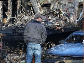 A family member surveys the damage to a garage Thursday, Jan. 17, 2013, at a home in the 1700 block of Lesperance Rd. in Tecumseh, Ont. An early morning fire destroyed the structure as well as several vintage motorcycles and antique collectibles.  (DAN JANISSE/The Windsor Star)