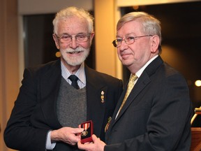 Photographer Spike Bell is awarded a Queen's Diamond Jubilee Medal by NDP MP Joe Comartin Wednesday, Jan. 23, at the Windsor Yacht Club. Bell received the recognition for assisting numerous charitable organizations. (Kristie Pearce/The Windsor Star)