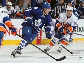 Toronto's Jake Gardiner, centre, gets around Mark Streit, left, of the New York Islanders during NHL action at the Air Canada Centre January 24, 2013 in Toronto. (Abelimages/Getty Images)