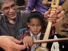 Files: The Multicultural Council of Windsor and Essex County has start a music therapy program for recent arrivals from war-torn and strife ridden countries. Here Nino Palazzolo, music coordinator for the project, shows Kap Sian Hoih, 4, how to play an instrument on May 12, 2011. (Windsor Star files)