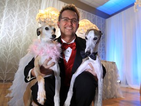 Shawn Amerlinck, owner of My Pet's Butler, holds his two dogs named Pepper and Jasper on the winter fantasy stage in the interactive wedding gallery created by RL Designs and Marz Lighting during  "The Big One" 26th Annual 2013 Wedding Extravaganza held at the Caboto Club in Windsor, Ontario.  Amerlink's owns the in-home professional pet car business and offers pet-care for brides and grooms on their wedding day.  (JASON KRYK / The Windsor Star)