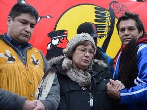 Attawapiskat Chief Theresa Spence holds hands with fellow hunger striker Jean Socks as she stands beside supporter Danny Metatawabin during a press conference outside her teepee on Victoria Island in Ottawa on Friday, January 4, 2013. Spence has been on a hunger strike for more than three weeks. THE CANADIAN PRESS/Sean Kilpatrick