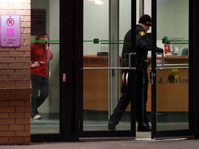 A woman talks on the phone as OPP officers investigate at the scene of a robbery at the TD Canada Trust bank on Tecumseh Road east of Banwell Road in Tecumseh on Thursday, January 31, 2013.         (TYLER BROWNBRIDGE / The Windsor Star)