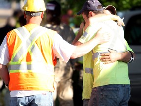 Construction workers console each other after a co-worker was struck by a front-end loader on the 1200 block of McKay Avenue on Wednesday, June 1, 2011.  (DYLAN KRISTY/The Windsor Star)